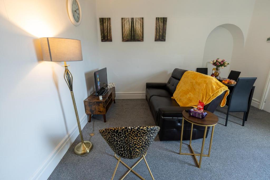 a living room with a black couch and a table at 5 Star Homes- Free Wifi & Parking, Contractor & family friendly in Pallion