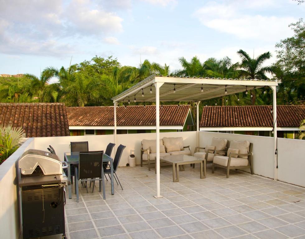 a patio with a table and chairs under a pavilion at The Nest 2 Bedroom1 Bath Condo Rooftop Patio in Coco