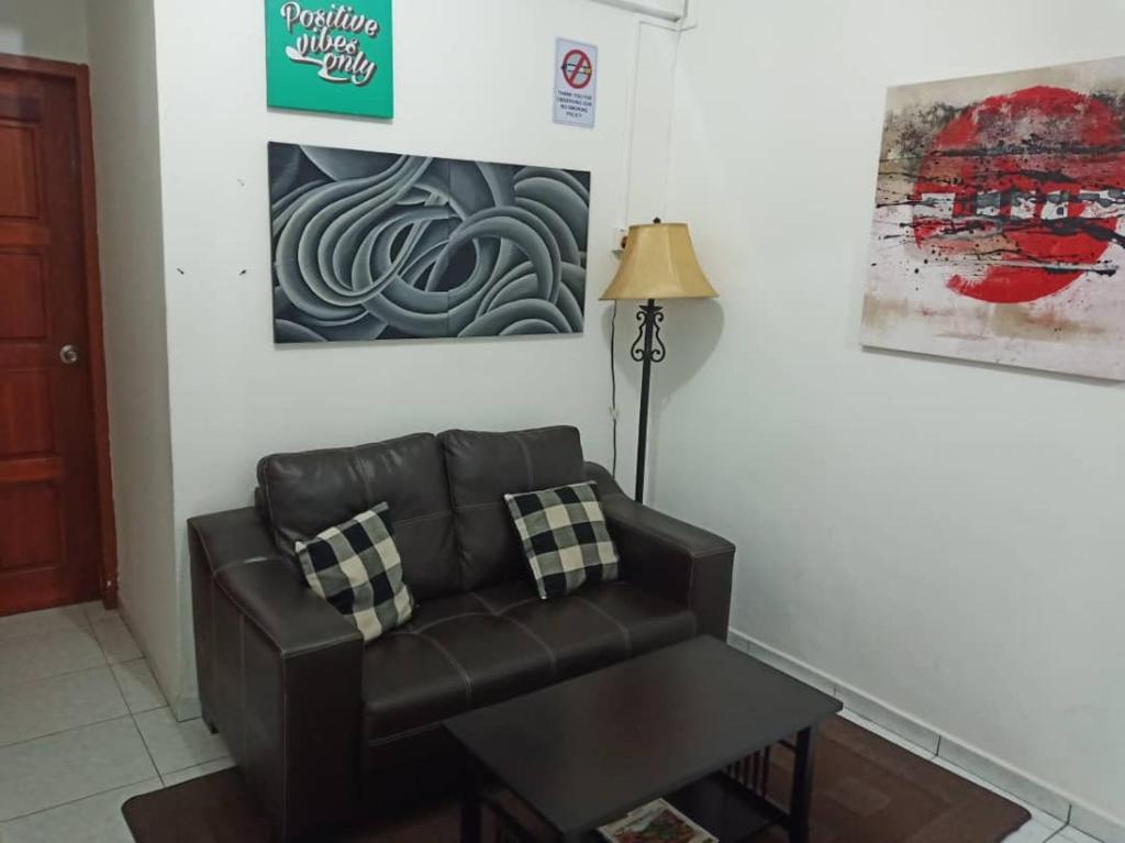 a living room with a leather couch and a table at check in hotel in Brinchang