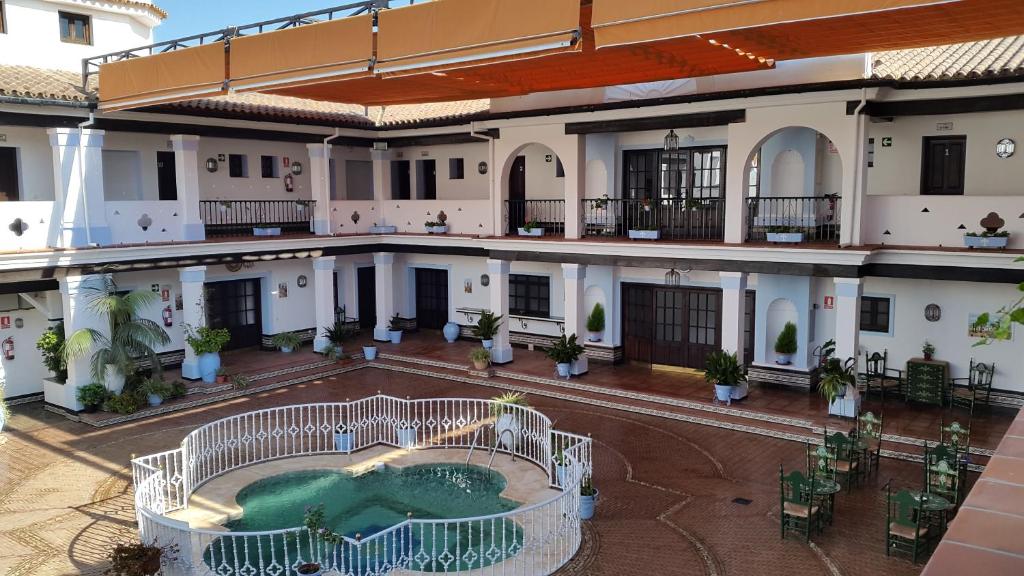 an aerial view of the courtyard of a building with a swimming pool at Palacio Doñana , Rural & Luxury in El Rocío