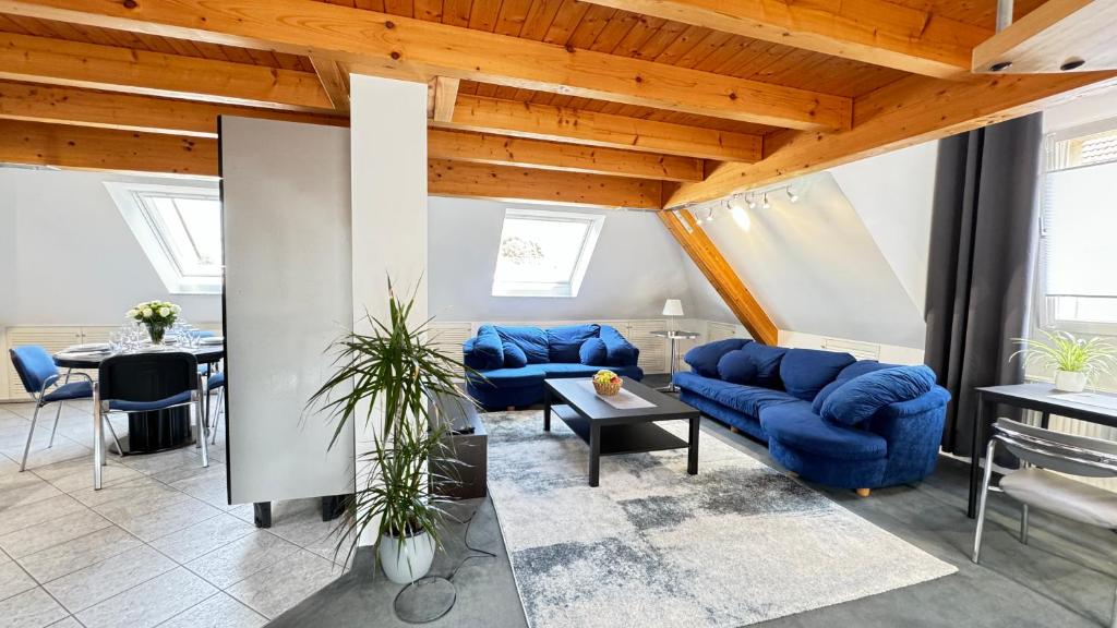 a living room with blue couches and a table at Loftapartment Wuppertal in Wuppertal