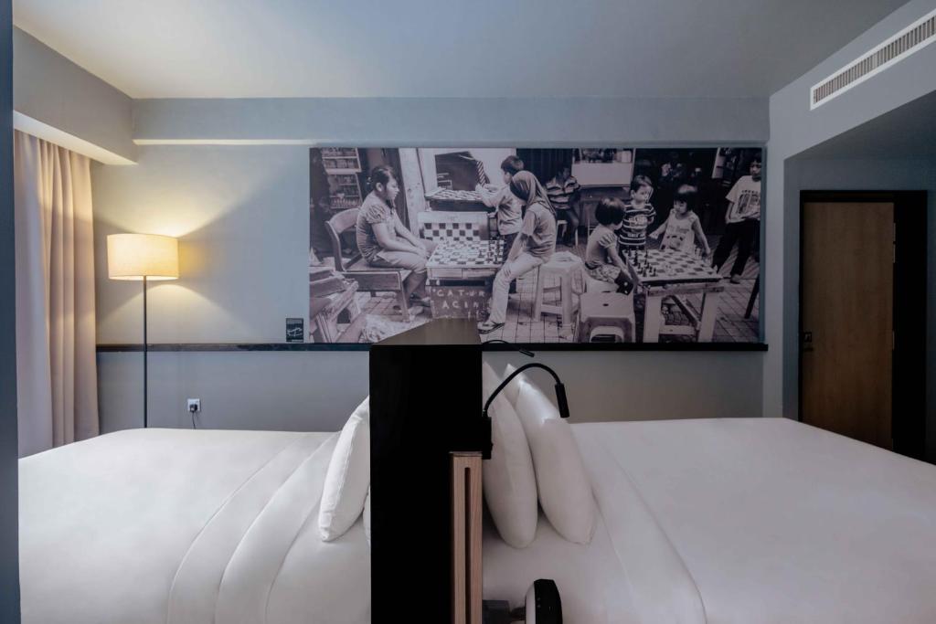 a hotel room with a bed and a picture on the wall at The Kuala Lumpur Journal Hotel in Kuala Lumpur