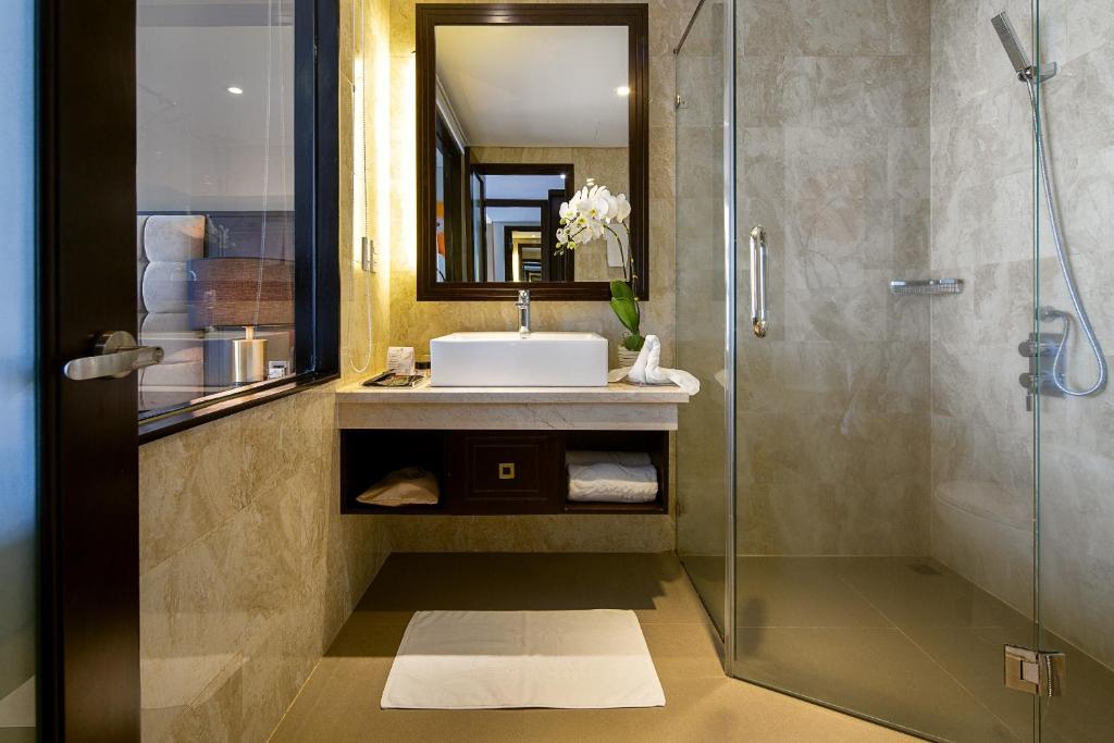 A compact marble-look bathroom with a glass-enclosed walk-in shower.