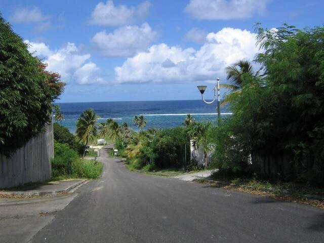 an empty street with a view of the ocean at Caraïbes - RDC in Le Moule