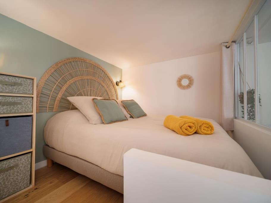 - une chambre avec un lit et des serviettes jaunes dans l'établissement La Cigale - Superbe Studio au coeur du Panier - Les Frères de la Loc', à Marseille