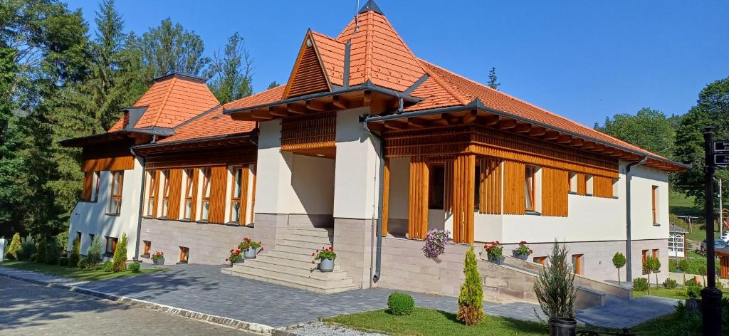 a small house with an orange roof at Villa Bellini Borszék in Borsec