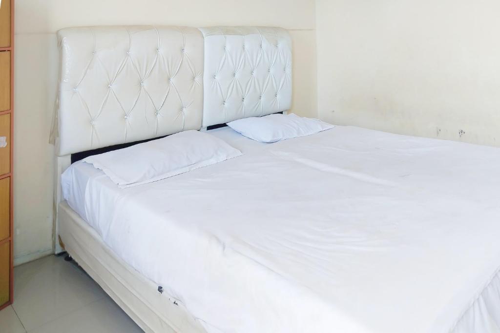 a large white bed with two pillows on it at Richmond Guest House Cirebon RedPartner in Cirebon