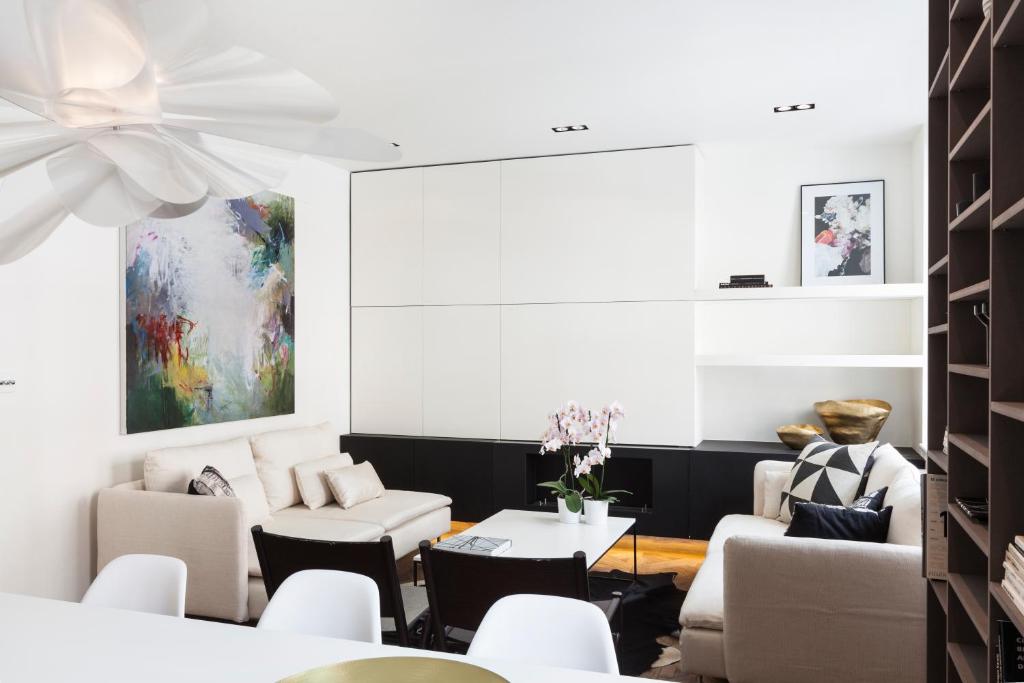 a living room with white furniture and a painting at Sophisticated Boutique Apartment in London