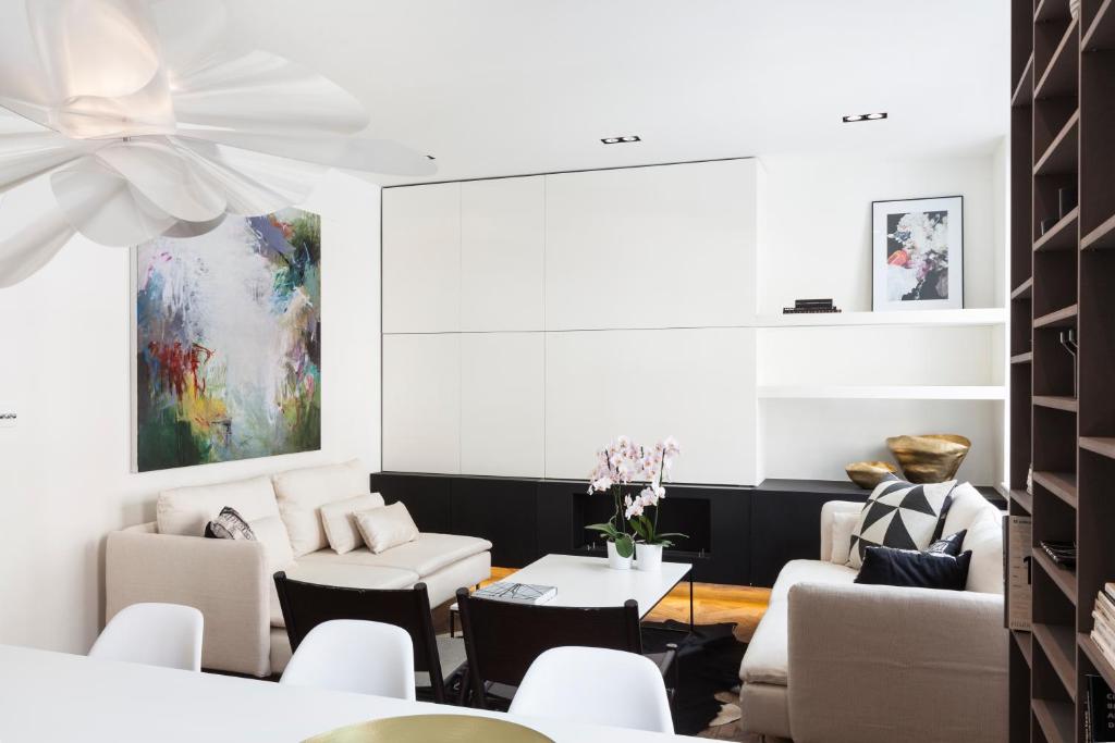 una sala de estar con muebles blancos y una pintura en Sophisticated Boutique Apartment, en Londres