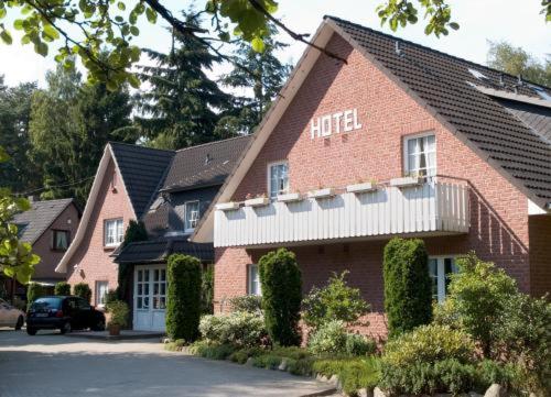 un edificio de ladrillo rojo con un cartel de hotel en Hotel Ferien auf der Heid en Eversen