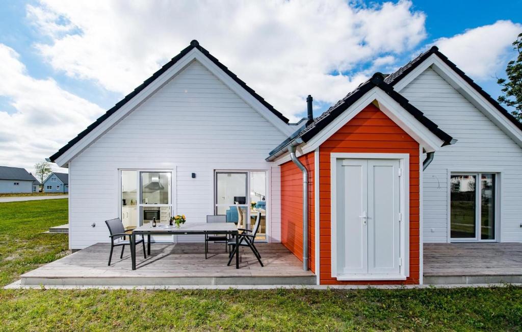 a white and orange house with a table and chairs at Happy Holidays in Olpenitz
