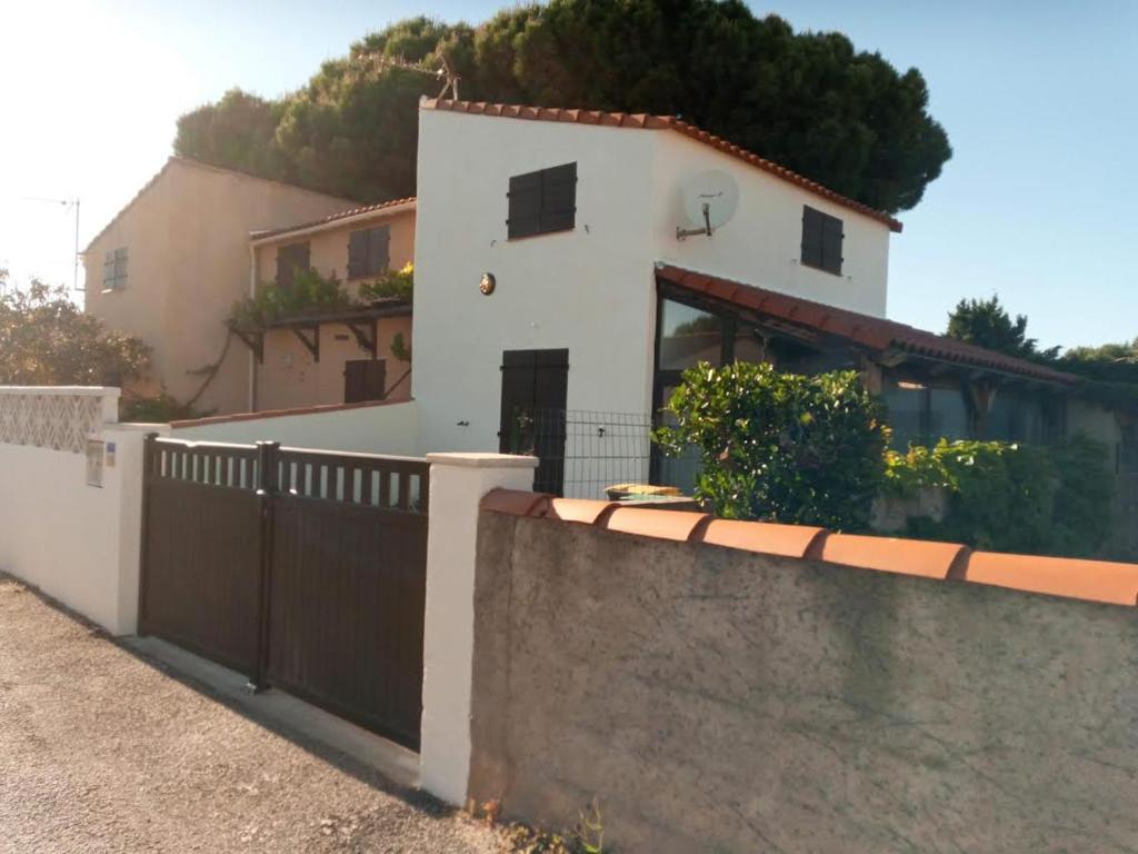 une maison blanche avec une clôture devant dans l'établissement les bleuets, à Sainte-Marie-la-Mer