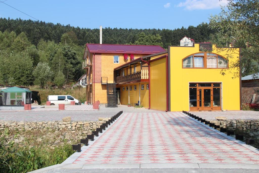 a large yellow building with a driveway in front of it at Садиба Леонтія in Skhidnitsa