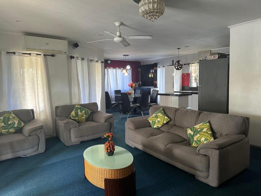 a living room with two couches and a table at Ac airport flats in Nadi