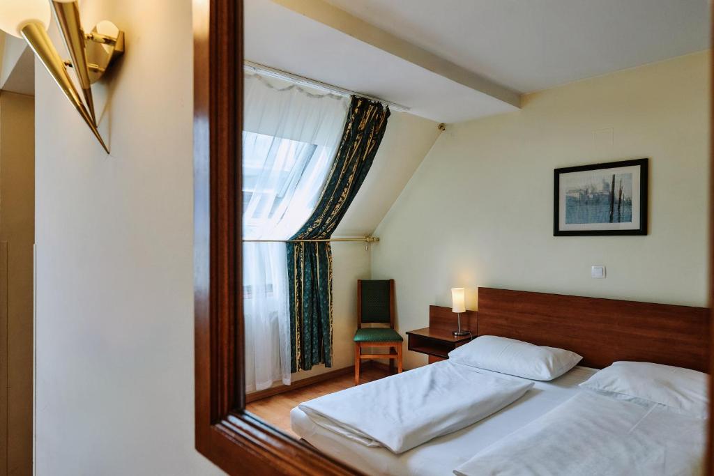 A bed or beds in a room at Hotel Deutschmeister