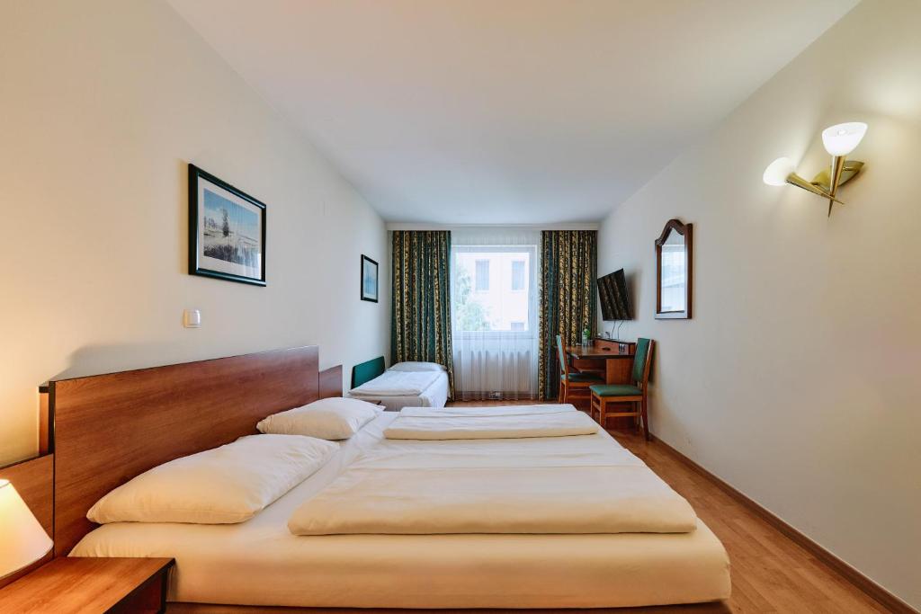 A bed or beds in a room at Hotel Deutschmeister