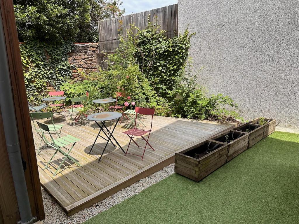 a garden with a table and chairs on a wooden deck at L 'experience Unique in Rennes