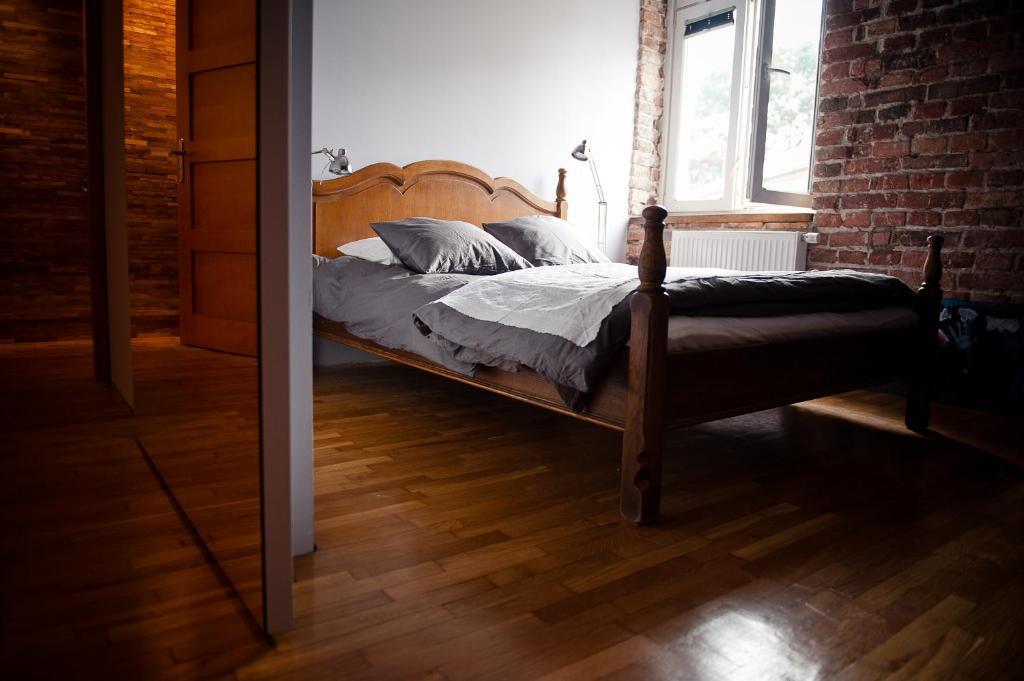 uma cama num quarto com uma parede de tijolos em Loft Apartment Industrial Design em Cracóvia