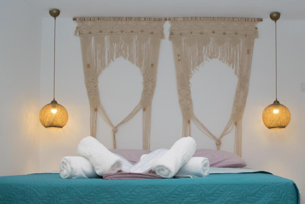 - un lit avec des draps et des oreillers blancs dans l'établissement Endless Blue from Syros - Megas Gialos Suite 2, à Liaropá