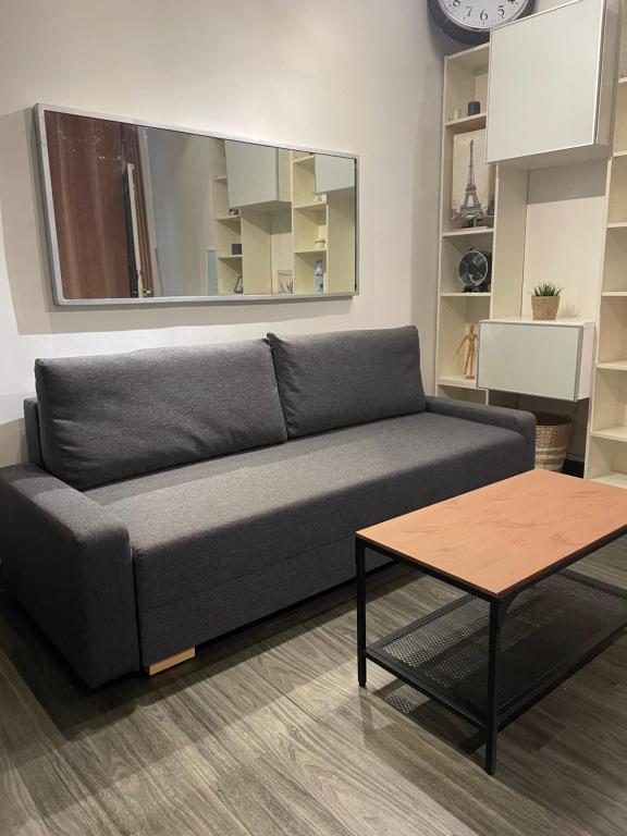 - un canapé gris dans le salon avec une table dans l'établissement Place de la Bastille, à Paris