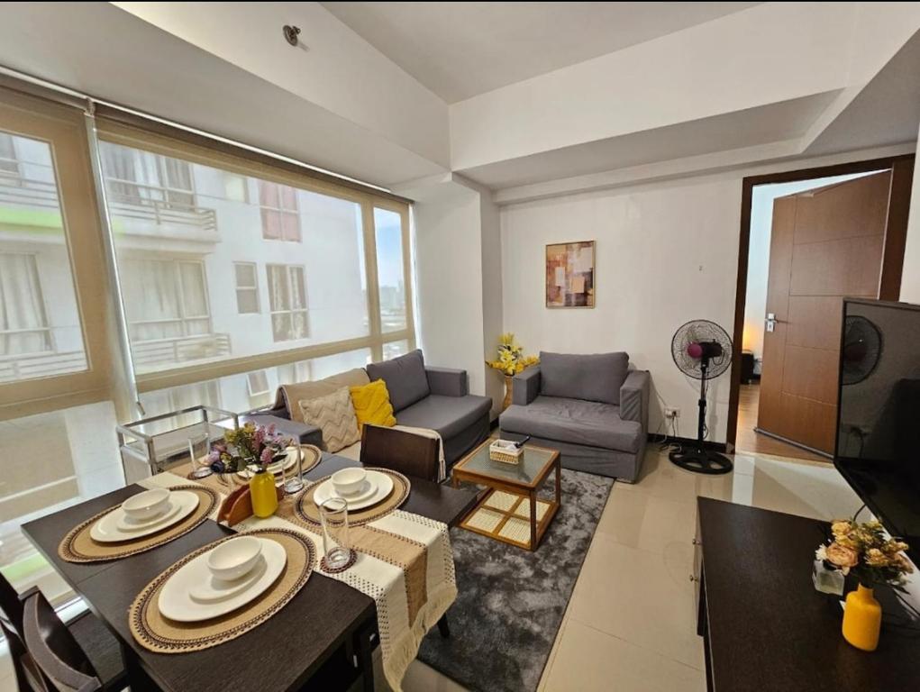 a living room with a couch and a table at Sunshine 100 Plaza - Bright and cozy 1 bedroom with washer in Manila