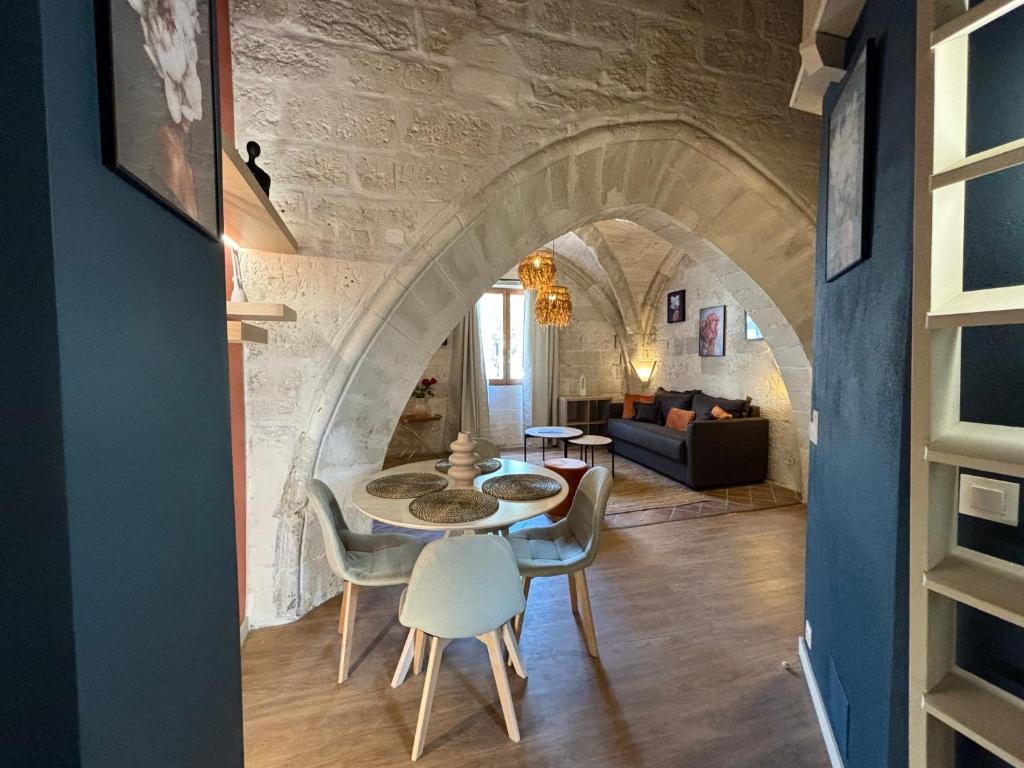 a living room with a table and chairs at Joli appartement voûté dans le centre ville in Avignon