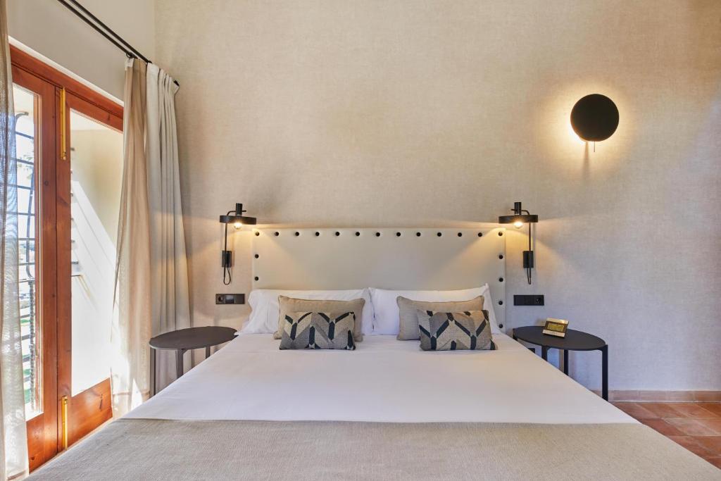 a bedroom with a large white bed with two tables at Virrey Finca Hotel in Inca