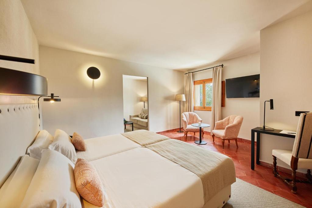 a bedroom with a large white bed and a desk at Virrey Finca Hotel in Inca