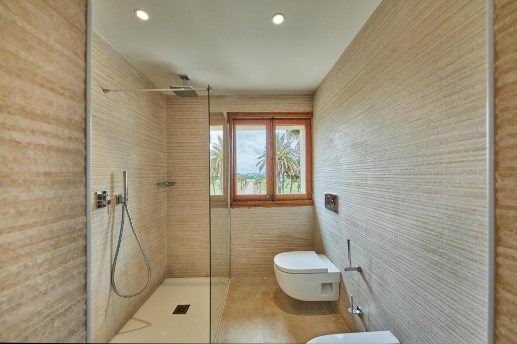a bathroom with a toilet and a glass shower at Virrey Finca Hotel in Inca