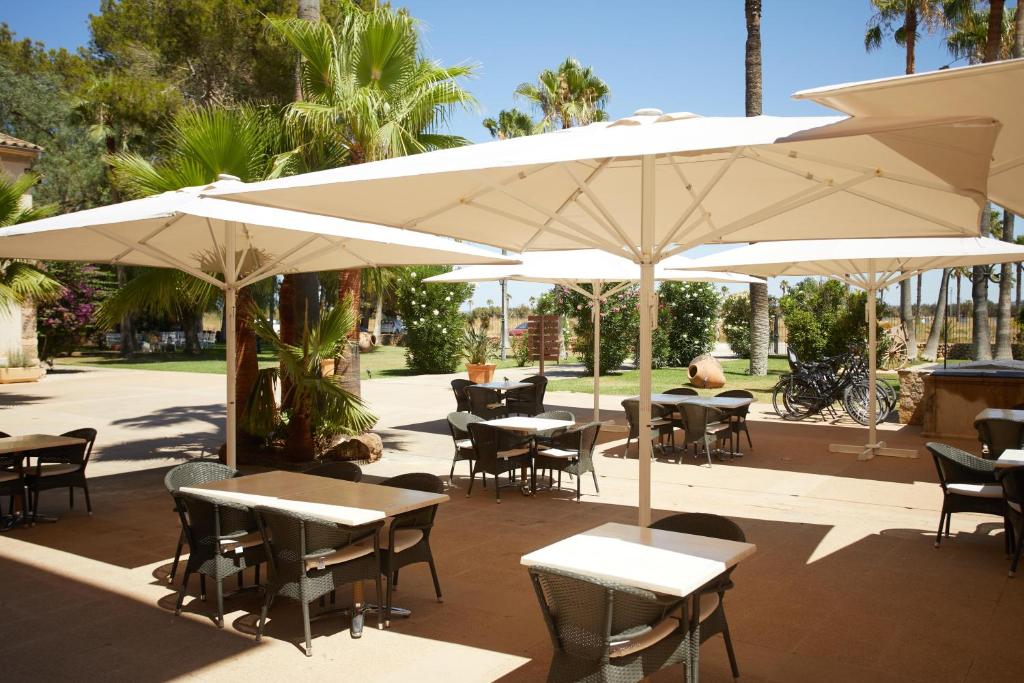 an outdoor patio with tables and chairs and umbrellas at Virrey Finca Hotel in Inca