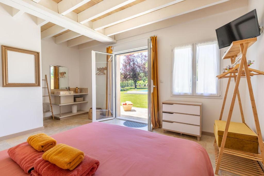 een slaapkamer met een groot roze bed met een televisie bij Le gîte L'As de Seur in Seur