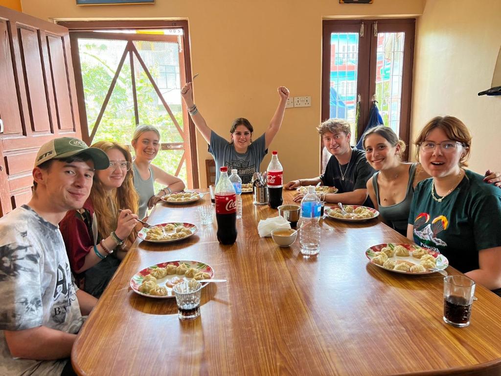 a group of people sitting around a table eating food at Hotel Diplomat in Pokhara