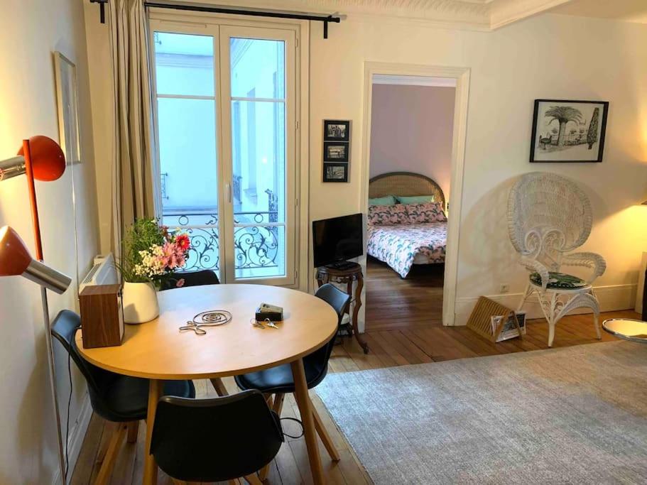 un salon avec une table et une chambre dans l'établissement Beau 2P au pied de Montmartre, à Paris