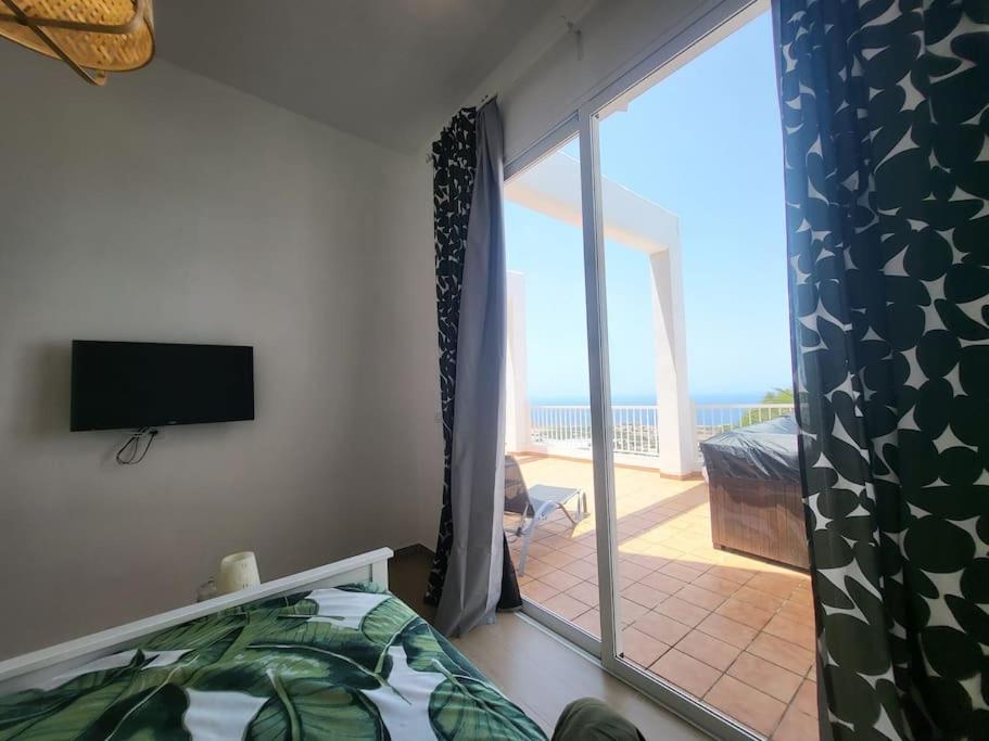 a bedroom with a sliding glass door to a balcony at La casita in Los Menores