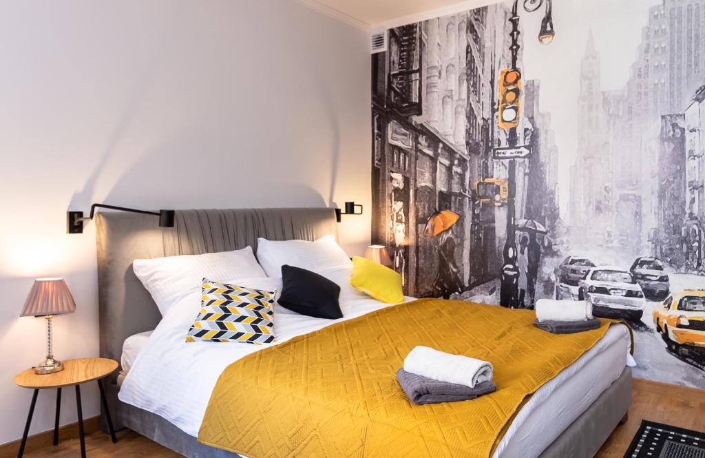 a bedroom with a large bed with a yellow blanket at Apartament Na Deptaku 23 in Lublin