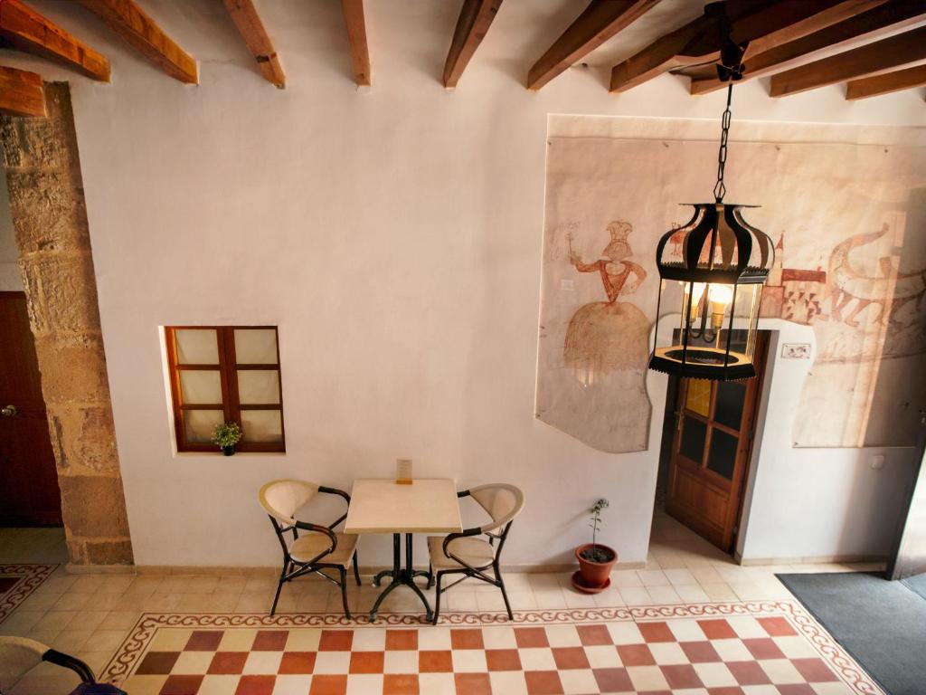 a dining room with a table and chairs and a chandelier at Petit Hotel Hostatgeria La Victoria in Alcudia