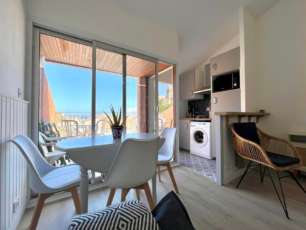 une cuisine et une salle à manger avec une table et des chaises dans l'établissement Appartement Collioure, grande terrasse et parking, à Collioure