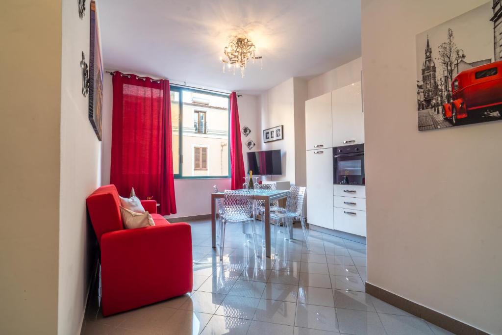 a living room with a red chair and a table at AlbaChiara in Alghero