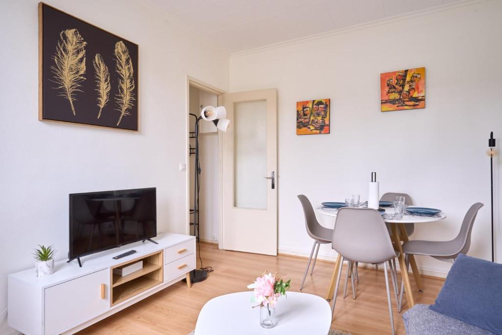 a living room with a tv and a table at Cosy T1 with garage near CDG | By Airnest in Le Blanc-Mesnil