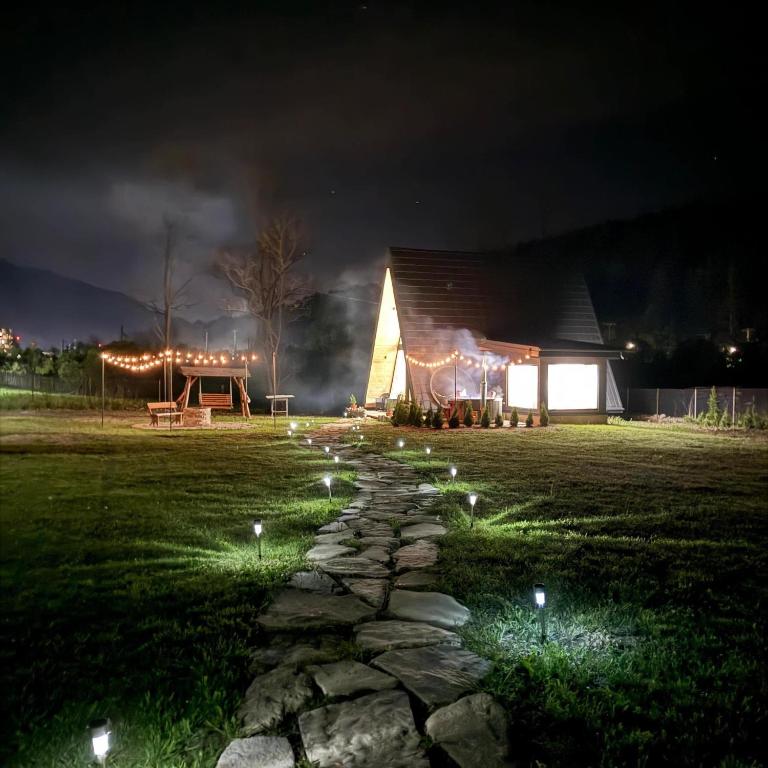 a stone path in front of a barn at night at Cabana A Vis in Taşca