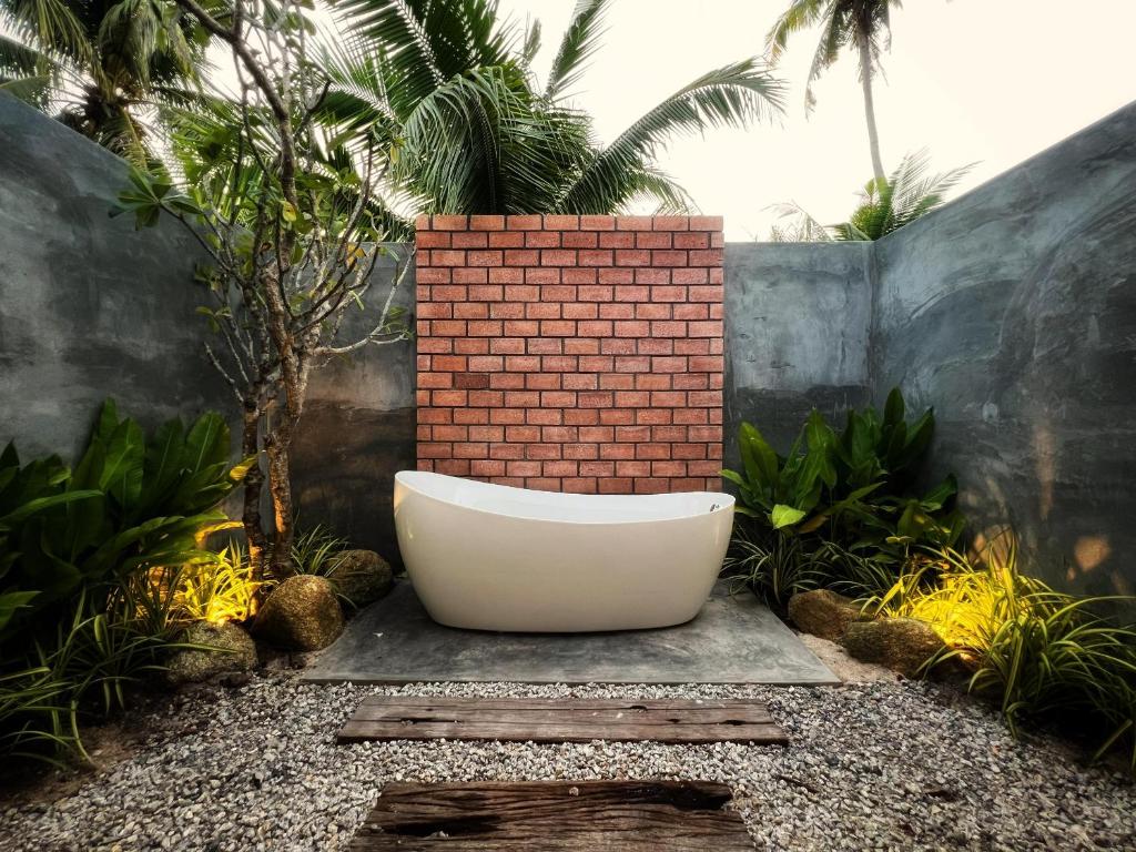パンタイチェナンにあるArchstudio Villaの庭園の中央にバスタブが備わります。