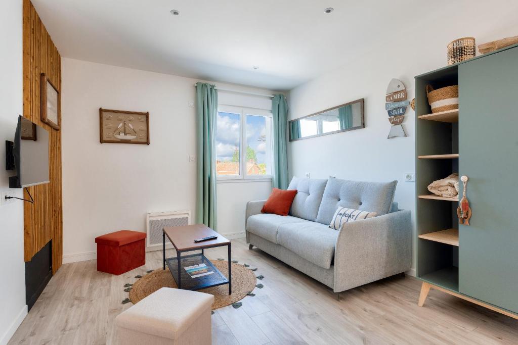 a living room with a couch and a table at 180m de la plage, quartier animé studio 2 personnes in La Tranche-sur-Mer