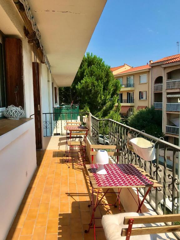 un patio avec tables et chaises sur un balcon dans l'établissement A 15mn des plages, beau duplex à Perpignan, à Perpignan