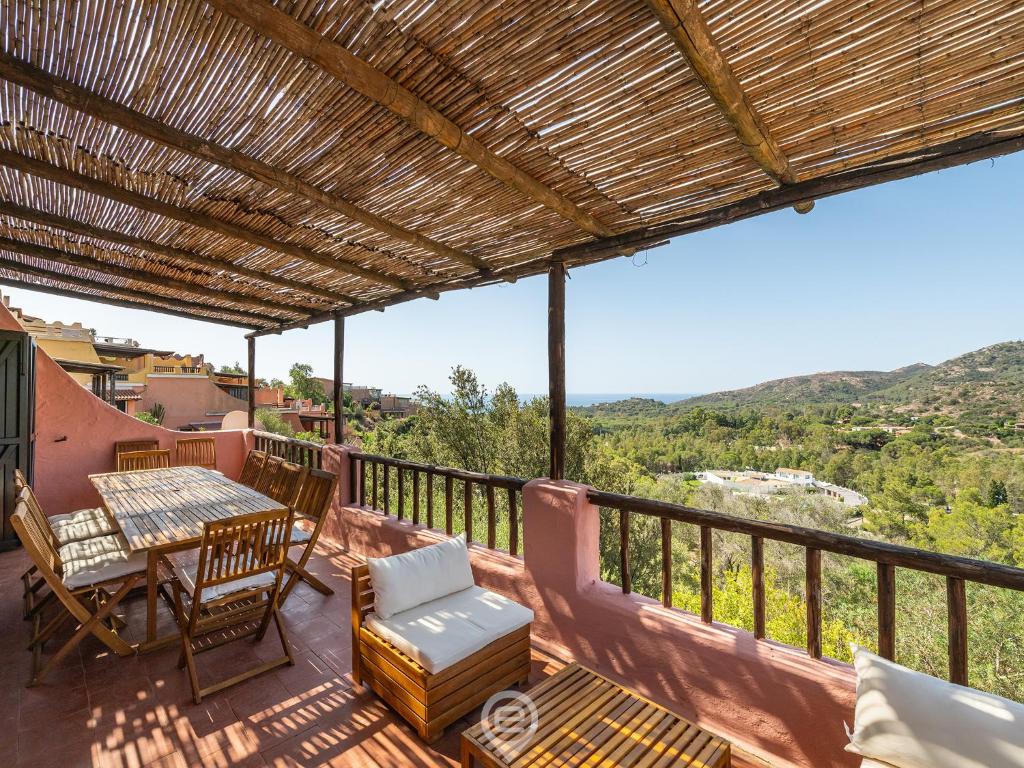 une terrasse avec une table et des chaises sur un balcon dans l'établissement Blue Eden Vista, à Domus de Maria