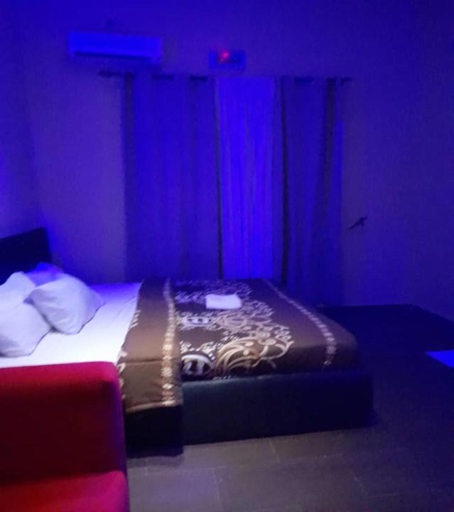 贝宁城Hotel Adonai Ltd的一间卧室配有一张蓝色灯床