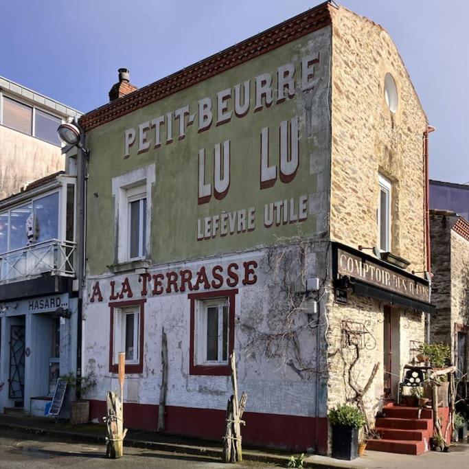 un vieux bâtiment avec un panneau sur son côté dans l'établissement Appartement vue Loire - Chez Lulu la Nantaise, à Rezé