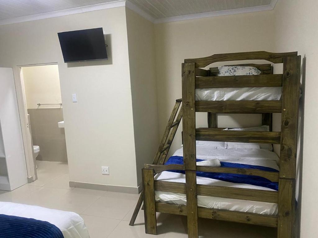 a bedroom with a bunk bed and a room with a television at Sabbath Lodge VIP in Cape Town
