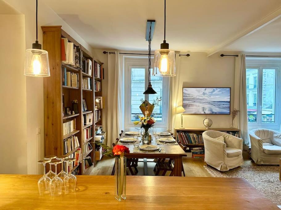 un salon avec une table, des chaises et des étagères dans l'établissement Cosy Chic Family Flat in Paris, à Paris
