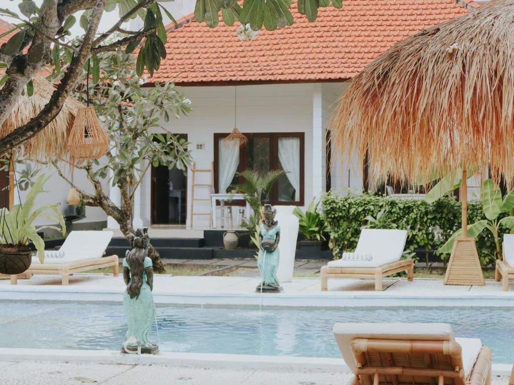 a swimming pool with chairs and a house at Oasis Boutique Villas in Nusa Lembongan