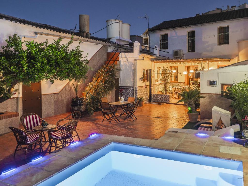 a backyard with a swimming pool and tables and chairs at Cubo's Noches de Luna Casabermeja House in Casabermeja